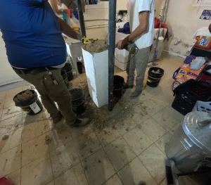 Contractors installing new steel power pole during foundation column replacement in Roanoke VA basement